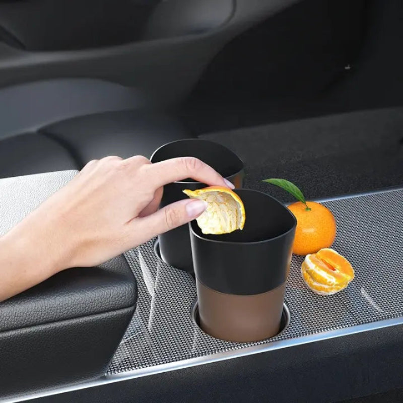 Démonstration d'une orange jetée dans une poubelle de voiture compacte
