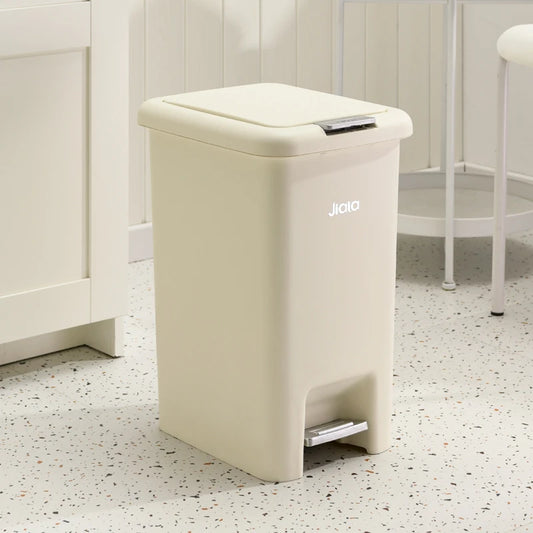 Poubelle de cuisine à pédale beige en face d'un meuble