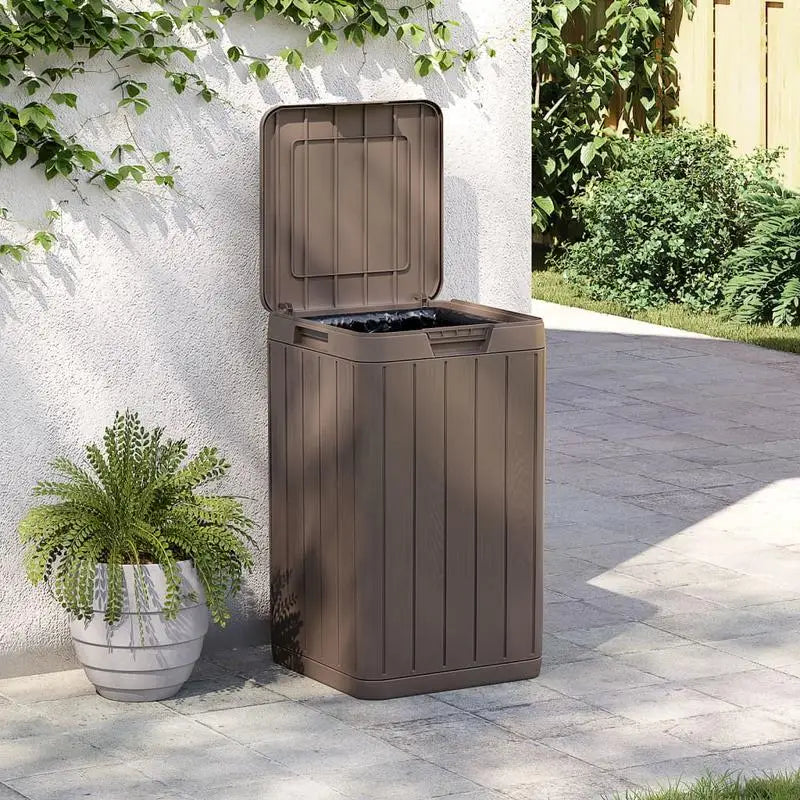 La Poubelle extérieure rigide marron 80L couvercle ouvert dans le jardin